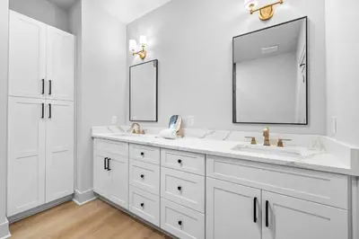 a white bathroom with two sinks and a mirror at Shimmy By The Sea by 30A Escapes in Panama City Beach