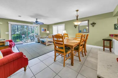 a dining room and living room with a table and chairs at Cassine Gardens 189 in Santa Rosa Beach