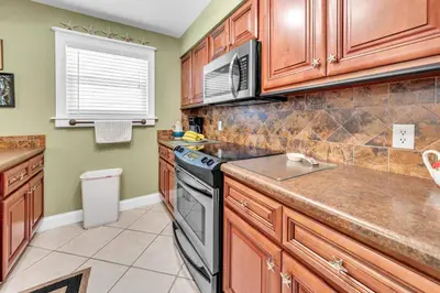 a kitchen with wooden cabinets and a stove at Cassine Gardens 189 in Santa Rosa Beach
