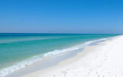 a beach with the ocean and a blue sky at Cassine Gardens 189 in Santa Rosa Beach