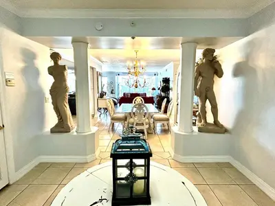 a living room with two statues of people on pillars at Hidden Dunes 203 in Panama City Beach