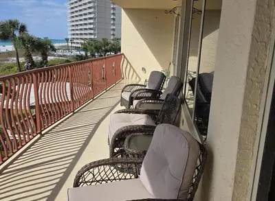 a row of wicker chairs sitting on a balcony at Hidden Dunes 203 in Panama City Beach