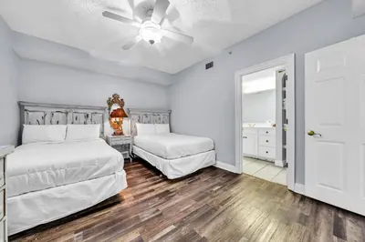 a bedroom with two beds and a ceiling fan at Hidden Dunes 203 in Panama City Beach