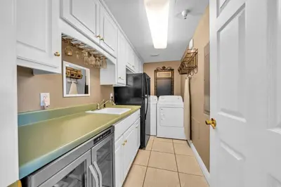 a kitchen with a sink and a washer and dryer at Hidden Dunes 203 in Panama City Beach