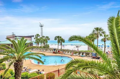 a view of a pool with palm trees and the beach at Hidden Dunes 203 in Panama City Beach