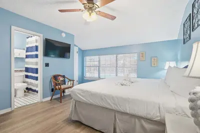 a bedroom with blue walls and a bed with a ceiling fan at 135 Grande Island Blvd in Panama City Beach