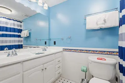 a blue bathroom with a toilet and a sink at 135 Grande Island Blvd in Panama City Beach