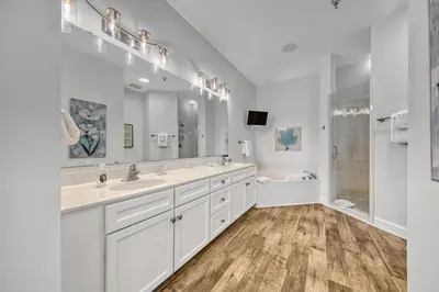 a white bathroom with two sinks and a tub at Newly renovated overlooking the Seacrest Village Pool and Beach access in Rosemary Beach