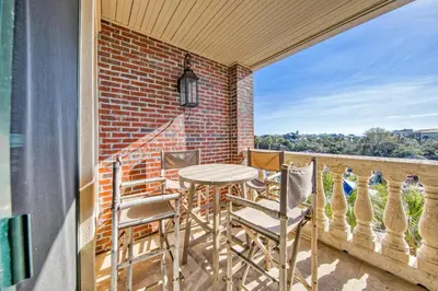 a patio with a table and chairs on a balcony at Newly renovated overlooking the Seacrest Village Pool and Beach access in Rosemary Beach