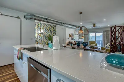 a kitchen with a counter top and a living room at Gulf Views! Only 30 Seconds to the beach Modern Amenities Meets Vintage Charm in Inlet Beach