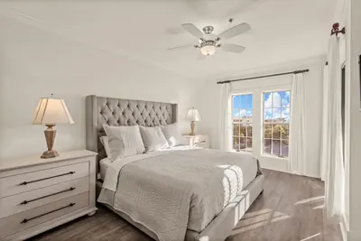 a white bedroom with a bed and a window at Newly Renovated Village Condo! Easy Beach & Pool Access! in Rosemary Beach