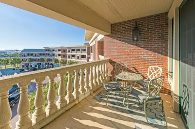 a patio with a table and chairs on a balcony at Newly Renovated Village Condo! Easy Beach & Pool Access! in Rosemary Beach