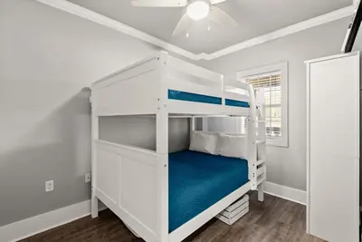 a bedroom with a bunk bed and a ceiling fan at Newly Renovated Village Condo! Easy Beach & Pool Access! in Rosemary Beach