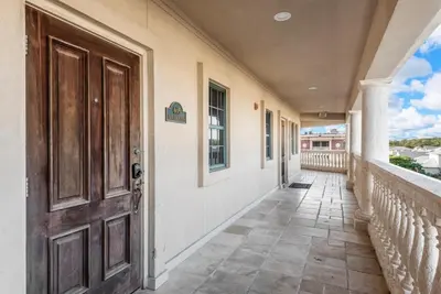 an empty hallway with a door and a balcony at Newly Renovated Village Condo! Easy Beach & Pool Access! in Rosemary Beach