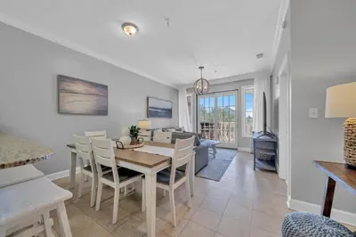 a dining room and living room with a table and chairs at Overlooking 30A! Great Location! Easy Beach & Pool Access! in Rosemary Beach