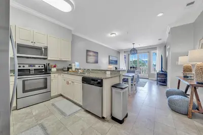 a kitchen with stainless steel appliances and a table at Overlooking 30A! Great Location! Easy Beach & Pool Access! in Rosemary Beach