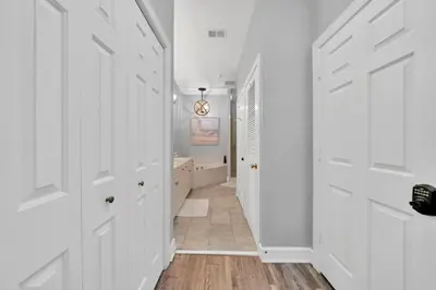 a hallway with white doors and a bathroom with a tub at Overlooking 30A! Great Location! Easy Beach & Pool Access! in Rosemary Beach