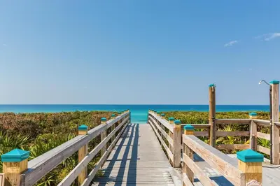 a boardwalk to the beach with the ocean in the background at Overlooking 30A! Great Location! Easy Beach & Pool Access! in Rosemary Beach