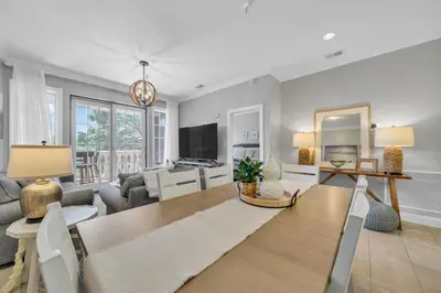 a living room with a table and a tv at Overlooking 30A! Great Location! Easy Beach & Pool Access! in Rosemary Beach