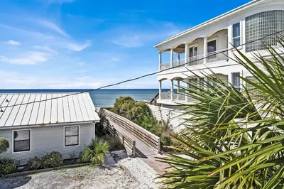 a white house with the ocean in the background at Gulf Front, Stunning Views! Newly Renovated! Dolphin Watch #1 in Seacrest