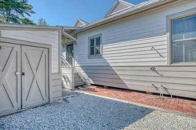 a house with a garage next to a building at Magnolia Cottages Seacrest Flirty Flamingo - Pet Friendly Resort Pool & Beach Access! in Seacrest