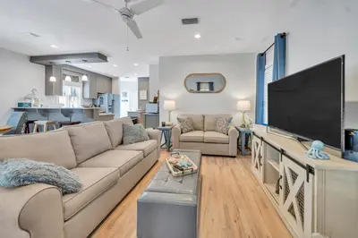 a living room with a large flat screen tv at Magnolia Cottages Seacrest Flirty Flamingo - Pet Friendly Resort Pool & Beach Access! in Seacrest