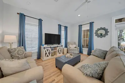 a living room with a couch and a tv at Magnolia Cottages Seacrest Flirty Flamingo - Pet Friendly Resort Pool & Beach Access! in Seacrest