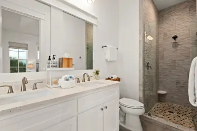 a white bathroom with a sink and a toilet at Katmanblu - Over 45 Five Star Reviews! Custom-Built! Easy Beach & Pool Access! in Rosemary Beach