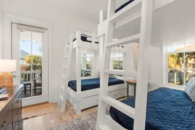 a bedroom with two bunk beds and a desk at Katmanblu - Over 45 Five Star Reviews! Custom-Built! Easy Beach & Pool Access! in Rosemary Beach