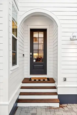 a black door on a white house at Katmanblu - Over 45 Five Star Reviews! Custom-Built! Easy Beach & Pool Access! in Rosemary Beach
