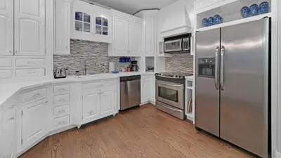 a kitchen with white cabinets and stainless steel appliances at Luxury Seacrest Beach Home Community Pool Deeded Beach Access! in Rosemary Beach