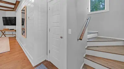a hallway with a white door and stairs in a house at Luxury Seacrest Beach Home Community Pool Deeded Beach Access! in Rosemary Beach