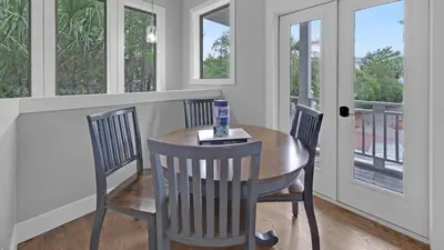 a dining room with a table and chairs and windows at Luxury Seacrest Beach Home Community Pool Deeded Beach Access! in Rosemary Beach