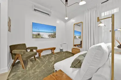 a bedroom with a bed and a chair and a table at Village of South Walton Studio Ground Floor Easy Beach & Pool Access! in Rosemary Beach