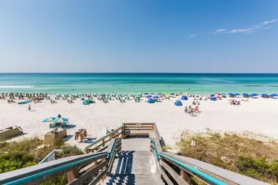 a beach with a bunch of people on the sand at Village of South Walton Studio Ground Floor Easy Beach & Pool Access! in Rosemary Beach