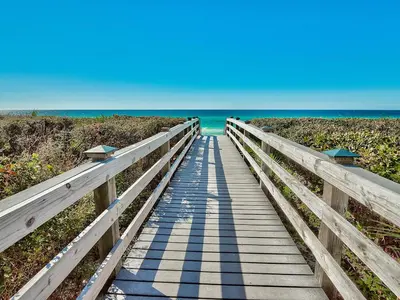 a wooden boardwalk leading to the ocean on a beach at Village of South Walton Studio Ground Floor Easy Beach & Pool Access! in Rosemary Beach
