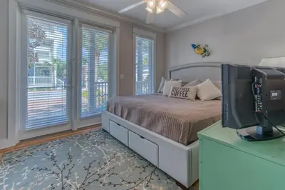 a bedroom with a bed and a tv and windows at 50 yards to the Seacrest lagoon Pool, Walking distance to the beach! in Rosemary Beach