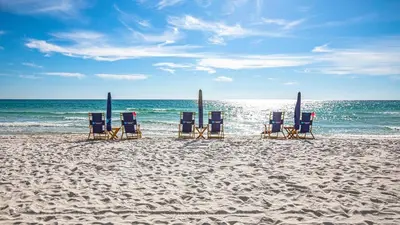 a group of chairs sitting on the beach at 50 yards to the Seacrest lagoon Pool, Walking distance to the beach! in Rosemary Beach