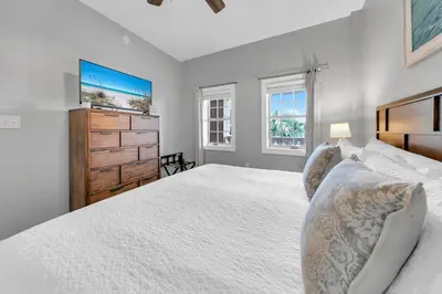 a white bedroom with a large bed and a dresser at Stunning Village Condo, Overlooking 30A, Beautifully Decorated Recently Updated in Rosemary Beach