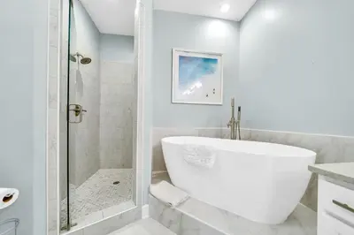 a white bathroom with a tub and a shower at Stunning Village Condo, Overlooking 30A, Beautifully Decorated Recently Updated in Rosemary Beach
