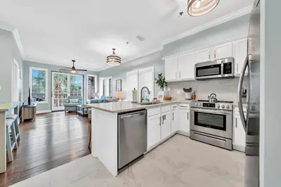 a kitchen with white cabinets and stainless steel appliances at Stunning Village Condo, Overlooking 30A, Beautifully Decorated Recently Updated in Rosemary Beach