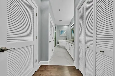 a bathroom with white doors and a tub and a sink at Stunning Village Condo, Overlooking 30A, Beautifully Decorated Recently Updated in Rosemary Beach