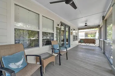 a porch with chairs and windows on a house at Pelicans Nest II - Easy walk to the beach & Pool in Santa Rosa Beach