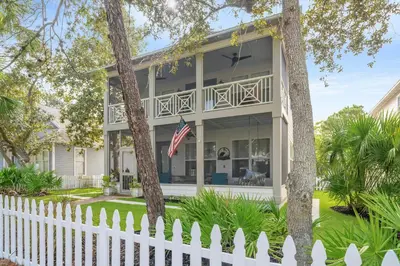 a white picket fence in front of a house at Pelicans Nest II - Easy walk to the beach & Pool in Santa Rosa Beach