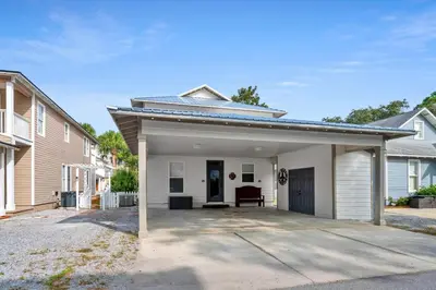 a house with a garage with a driveway at Pelicans Nest II - Easy walk to the beach & Pool in Santa Rosa Beach