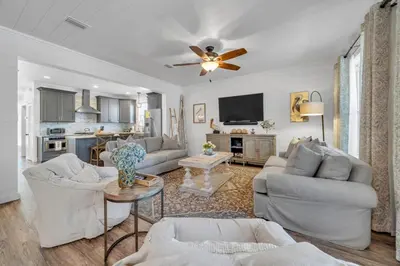 a living room with white furniture and a ceiling fan at Pelicans Nest II - Easy walk to the beach & Pool in Santa Rosa Beach