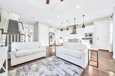 a living room with two white couches and a kitchen at NatureWalk on 30A Overlooking Beautiful Pond! in Seagrove Beach