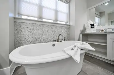 a white bathroom with a tub and a window at NatureWalk on 30A Overlooking Beautiful Pond! in Seagrove Beach