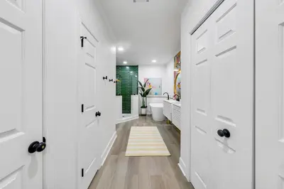 a hallway with white doors and a rug at Newly Renovated Professionally Decorated Gulf Views! Pool & Beach Access in Rosemary Beach