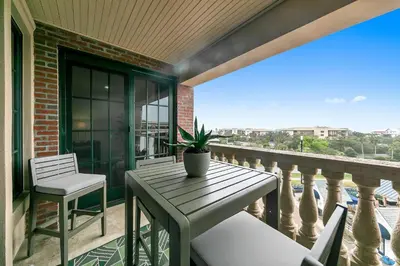 a porch with a table and chairs on a balcony at Newly Renovated Professionally Decorated Gulf Views! Pool & Beach Access in Rosemary Beach